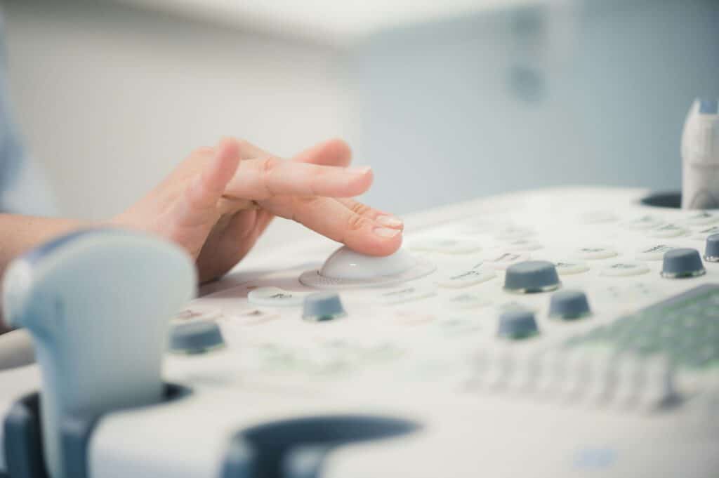 young woman doctor's hands close up preparing for an ultrasound device scan.